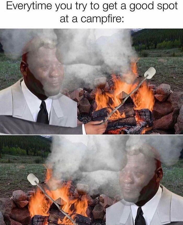 Man at a campfire getting smoke blown in his face, illustrating relatable moments in memes about the human experience.