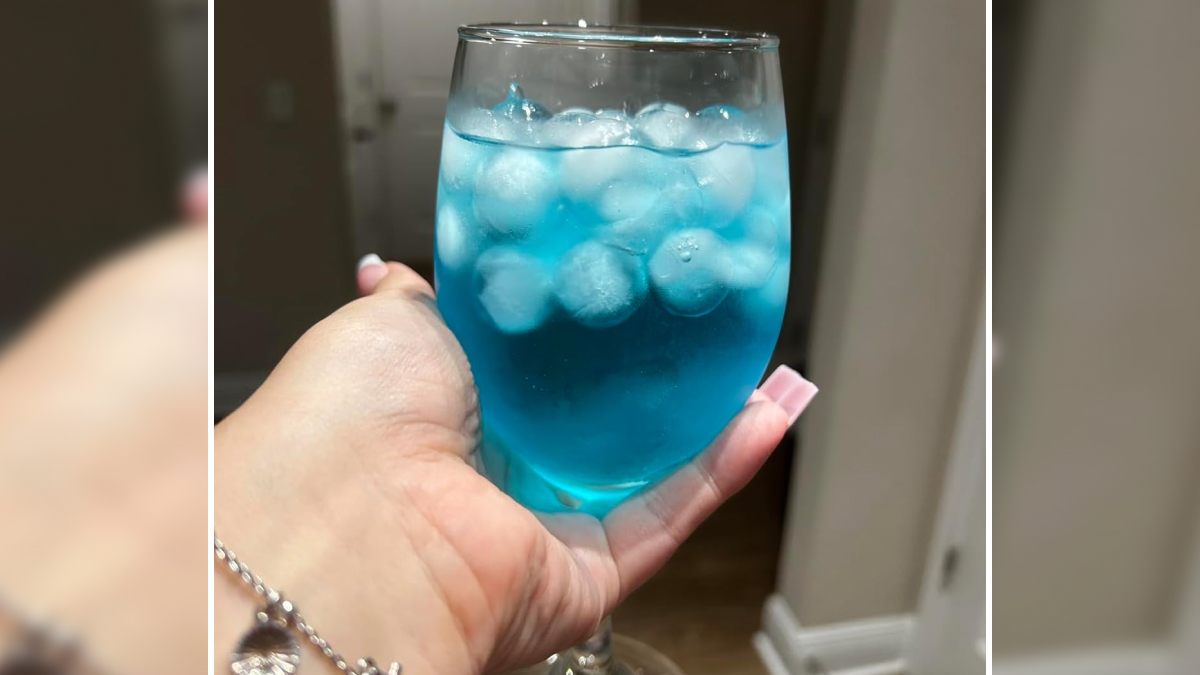 Hand holding a glass of blue iced drink, one of the popular TikTok finds trending on social media pages.