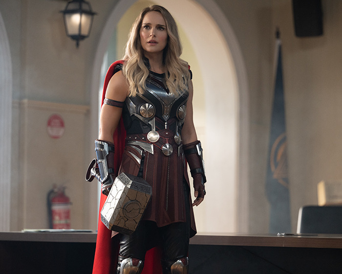 Woman dressed as Thor holding a hammer, representing an A-List star in a vlogger scenario without realizing her presence. Woman dressed as Thor holding a hammer, representing an A-List star in a vlogger scenario without realizing her presence.