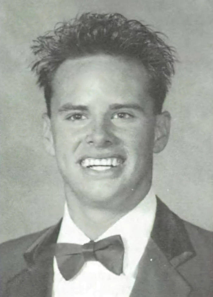Young Walton Goggins in a vintage yearbook photo wearing a tuxedo and bow tie, showing a big smile.