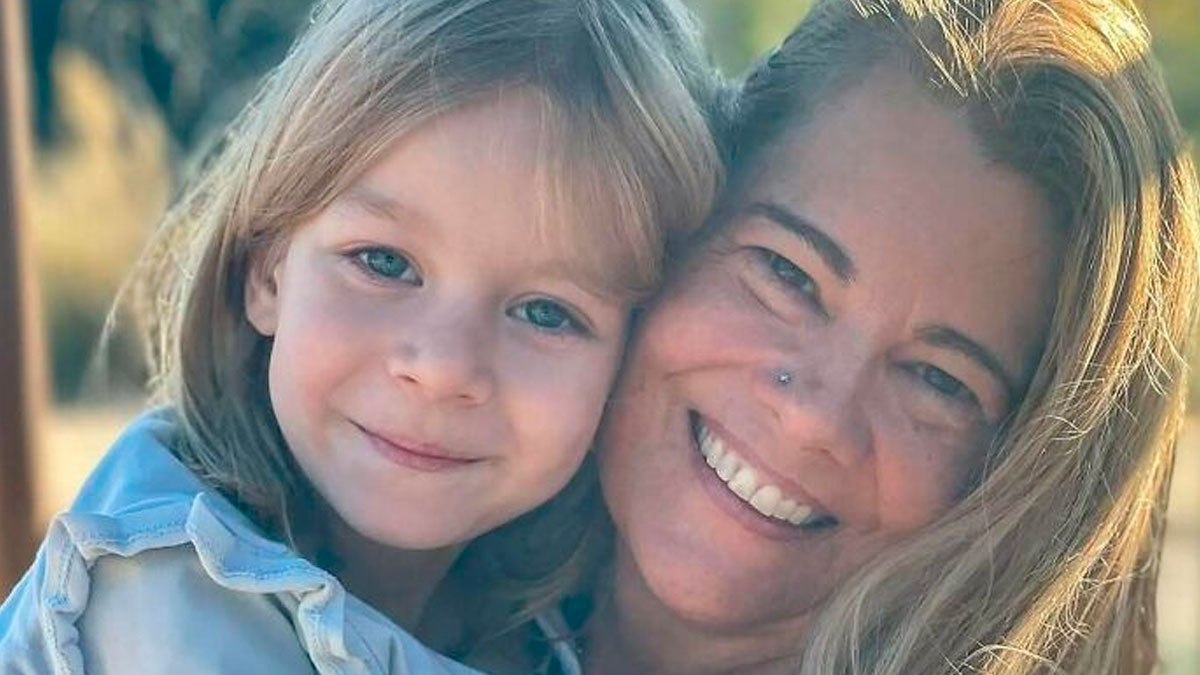 Smiling woman and child close together outdoors, capturing a heartwarming celebrity encounters moment.