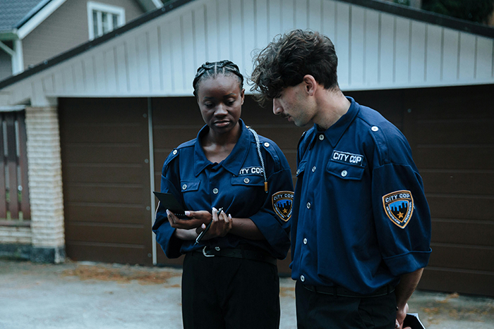 Two city cops in uniform outside a house discussing a case involving a man who called CPS about his sisters. Two city cops in uniform outside a house discussing a case involving a man who called CPS about his sisters.
