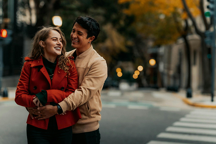 Man hugs woman on city street during autumn, illustrating family reaction to mom leaving little sisters alone. Man hugs woman on city street during autumn, illustrating family reaction to mom leaving little sisters alone.