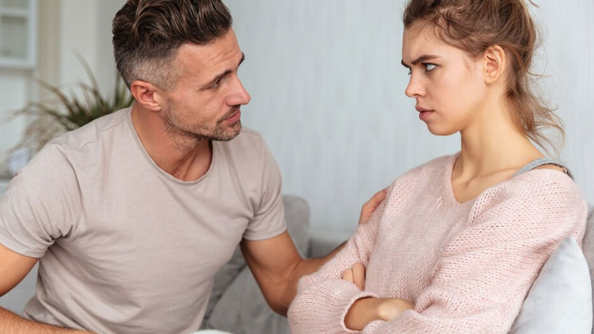 Couple in a tense conversation as woman refuses to wear fiancu00e9u2019s momu2019s used wedding dress during dispute.