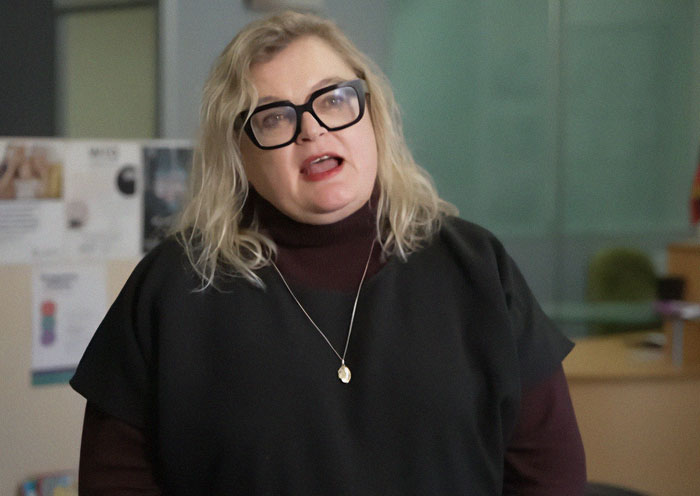 University professor with glasses speaking about women and men in domestic violence debate indoors. University professor with glasses speaking about women and men in domestic violence debate indoors.