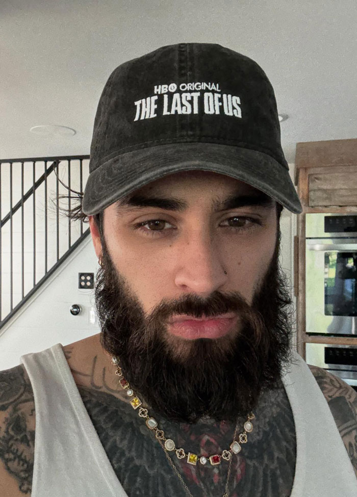 Close-up of a former band member with a thick beard and cap, looking almost unrecognizable in a casual indoor setting. Close-up of a former band member with a thick beard and cap, looking almost unrecognizable in a casual indoor setting.