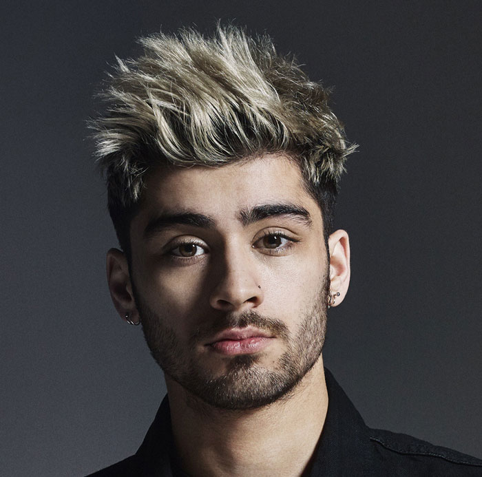 Young man with spiked blonde and black hair and earrings, former band member looks unrecognizable in this close-up portrait. Young man with spiked blonde and black hair and earrings, former band member looks unrecognizable in this close-up portrait.