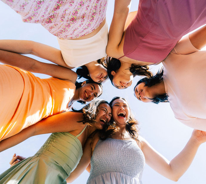 Group of women in colorful dresses standing in a circle outdoors, depicting a man hiring a PI about his partner. Group of women in colorful dresses standing in a circle outdoors, depicting a man hiring a PI about his partner.