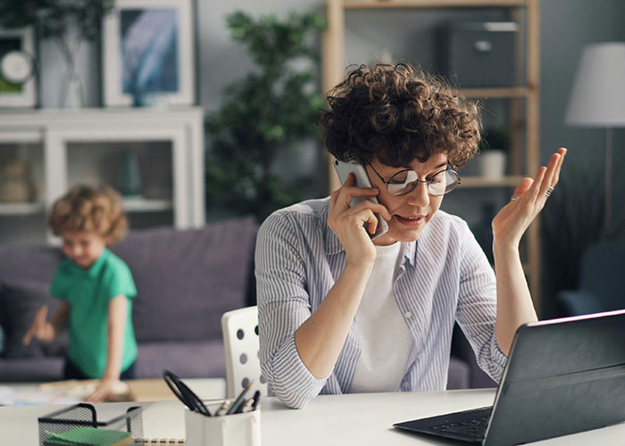 Woman assumes neighbor will babysit while being a SAHM, upset on phone call, child playing in the background at home. Woman assumes neighbor will babysit while being a SAHM, upset on phone call, child playing in the background at home.