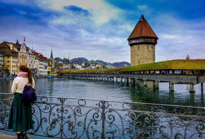 A woman overlooking historic wooden bridge in one of the best countries to live in 2025 with scenic riverside views. A woman overlooking historic wooden bridge in one of the best countries to live in 2025 with scenic riverside views.
