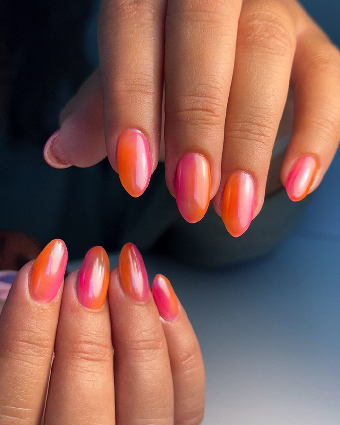 Glossy summer nails in vibrant pink and orange shades on almond-shaped nails, showcasing latest summer nails trends.
