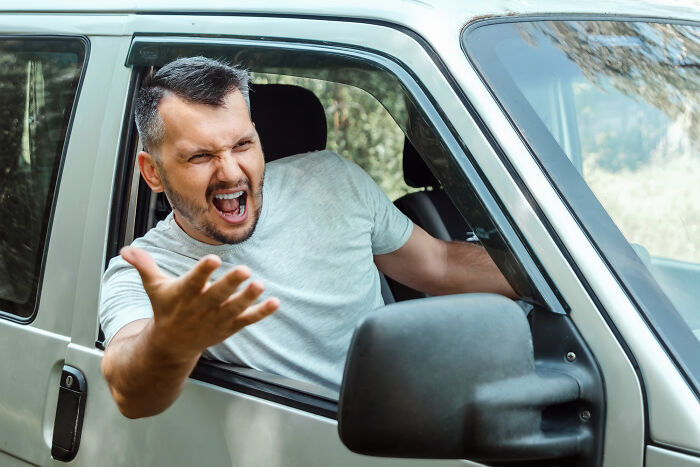 Man expressing frustration while sitting in the driver's seat of a car, reflecting honest thoughts about the UK.