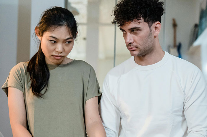 Wife looking grossed out and husband appearing frustrated during a tense moment in their relationship. Wife looking grossed out and husband appearing frustrated during a tense moment in their relationship.