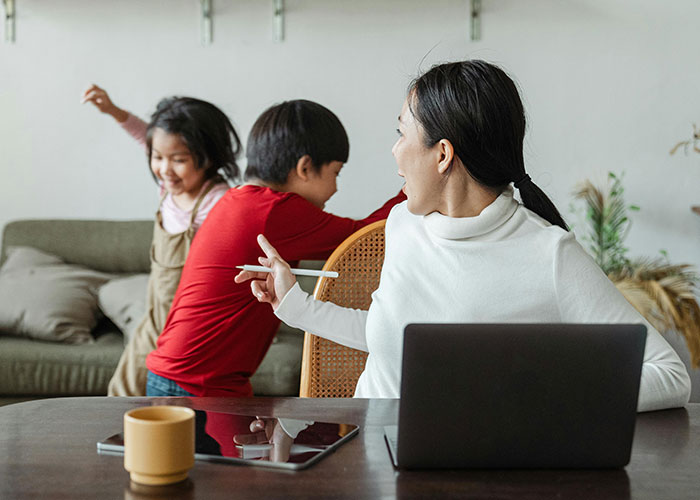 Mom assumes neighbor will babysit while she works on laptop, showing frustration after being declined in a home setting. Mom assumes neighbor will babysit while she works on laptop, showing frustration after being declined in a home setting.