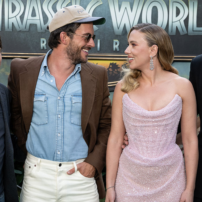 Scarlett Johansson in a sparkling pink dress smiling and posing with her costar at a movie premiere event. Scarlett Johansson in a sparkling pink dress smiling and posing with her costar at a movie premiere event.