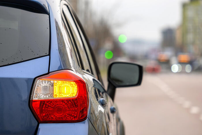 Close-up of a car's rear light turned on on a city street, illustrating the good trend slowly disappeared in traffic safety.