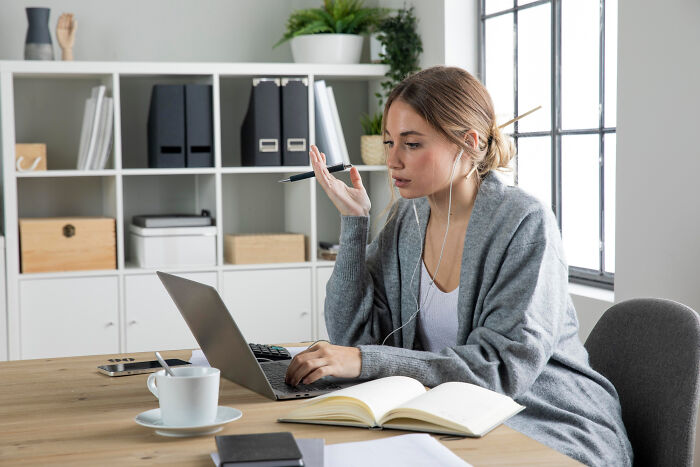 Woman working on laptop in home office, illustrating professions that attract the most awful people and finance bros.