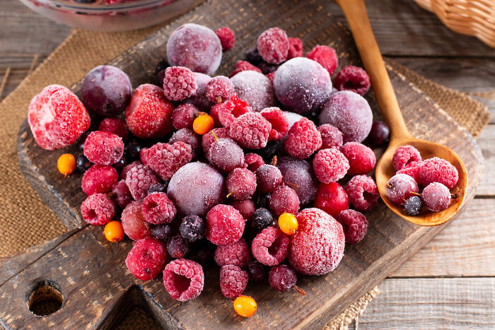 Assorted frozen berries on a wooden board with a spoon, illustrating best processed foods for weight loss. Assorted frozen berries on a wooden board with a spoon, illustrating best processed foods for weight loss.