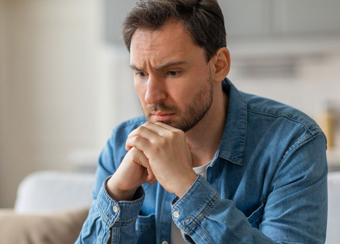 Man looking distressed and contemplative after unexpected investigation results from private investigator about partner. Man looking distressed and contemplative after unexpected investigation results from private investigator about partner.
