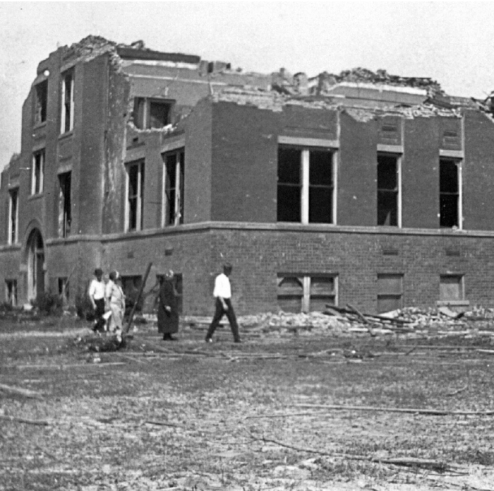 Damaged building and people walking through debris after the worst tornado in US history with 695 lives lost. Damaged building and people walking through debris after the worst tornado in US history with 695 lives lost.