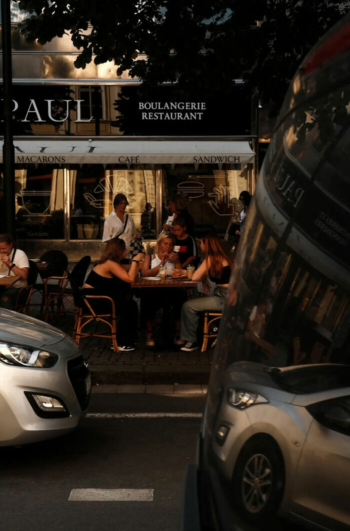 People enjoying a street cafe scene captured in beautiful street shots that highlight the poetry of everyday life.