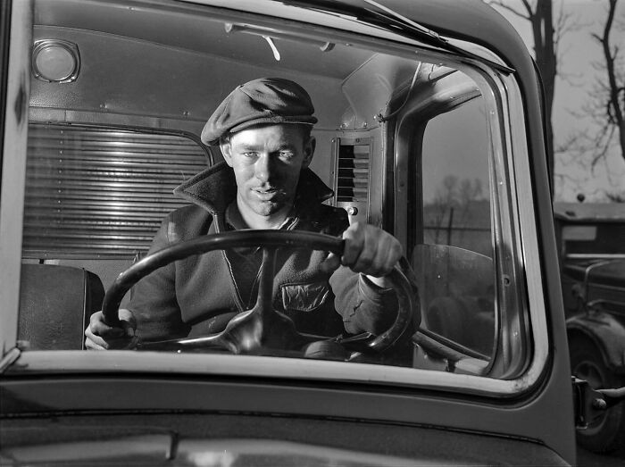 Colorized historical photo of a man driving a vintage truck, showcasing magical historical photos by talented viral artist.