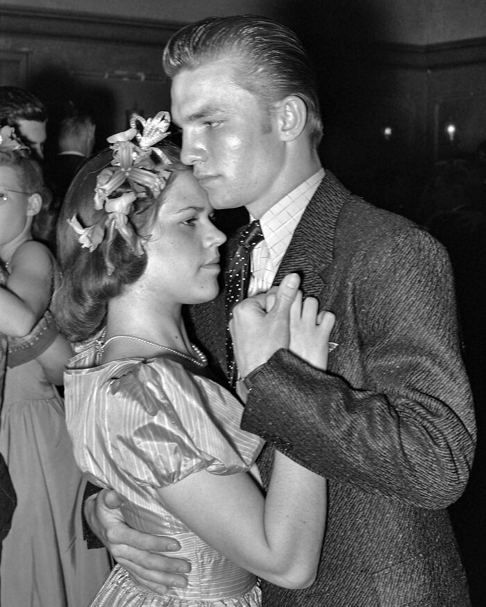 Young couple dancing closely at a formal event, a magical historical photo colorized by a talented viral artist.