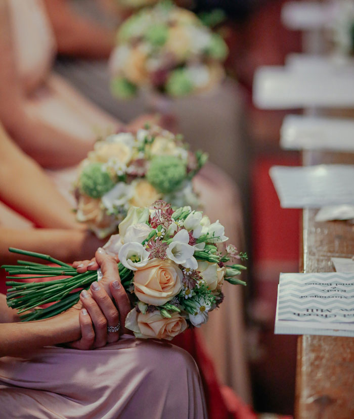 Bride and maid of honor holding floral bouquets during wedding ceremony, highlighting maid of honor pregnancy weight dispute. Bride and maid of honor holding floral bouquets during wedding ceremony, highlighting maid of honor pregnancy weight dispute.