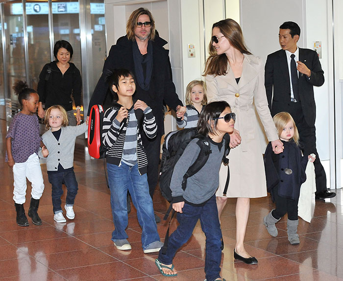 Brad Pitt walking with children in an airport, highlighting Brad Pitt cut off all contact with sons news. Brad Pitt walking with children in an airport, highlighting Brad Pitt cut off all contact with sons news.