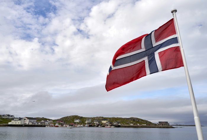 Norwegian flag waving by a coastal village, illustrating one of the best countries to live in 2025 with scenic landscapes. Norwegian flag waving by a coastal village, illustrating one of the best countries to live in 2025 with scenic landscapes.