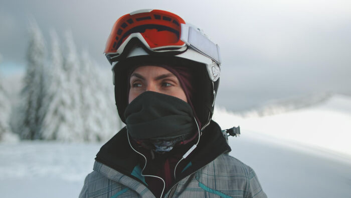 Person wearing ski gear and orange goggles in snowy landscape, evoking the theme of completely legal total psychopath.