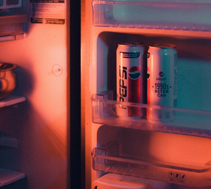 Two retro Pepsi cans on a refrigerator door shelf, symbolizing middle class nostalgic lifestyle shared by netizens.