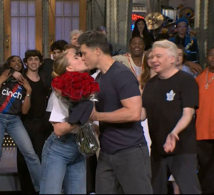 Scarlett Johansson kissing costar on the lips at premiere, holding red roses, surrounded by smiling cast members. Scarlett Johansson kissing costar on the lips at premiere, holding red roses, surrounded by smiling cast members.
