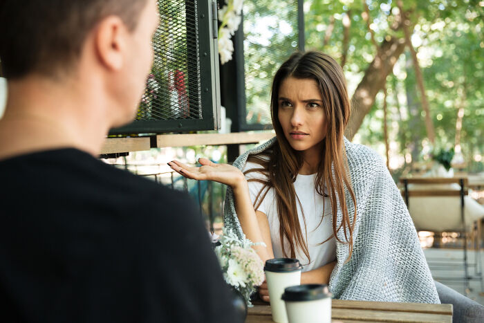 Woman wrapped in a blanket looking frustrated during a tense date, illustrating one of 28 dates that went sour.