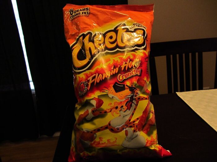 Bag of Flamin Hot Cheetos on a table highlighting surprising foods banned in the USA due to food regulations.