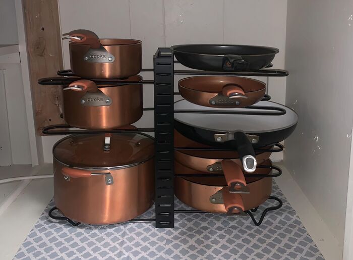 Organized copper pots and pans stored neatly on a kitchen rack, showcasing best-selling kitchen items for easy access.