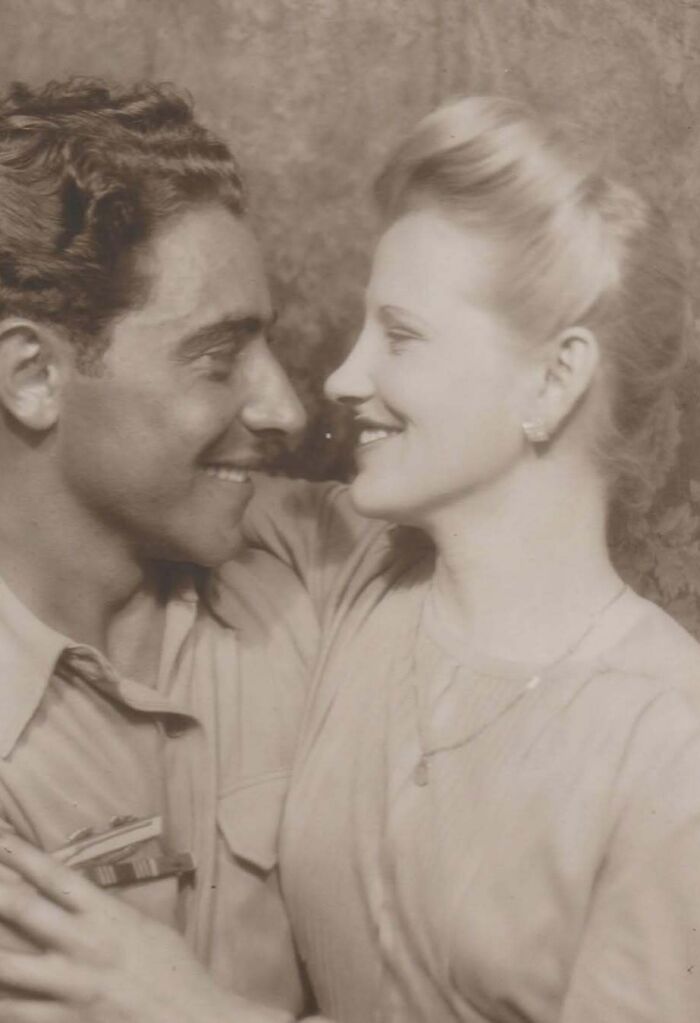 Vintage photo of a smiling couple embracing, showcasing a timeless and mesmerizing moment from history.