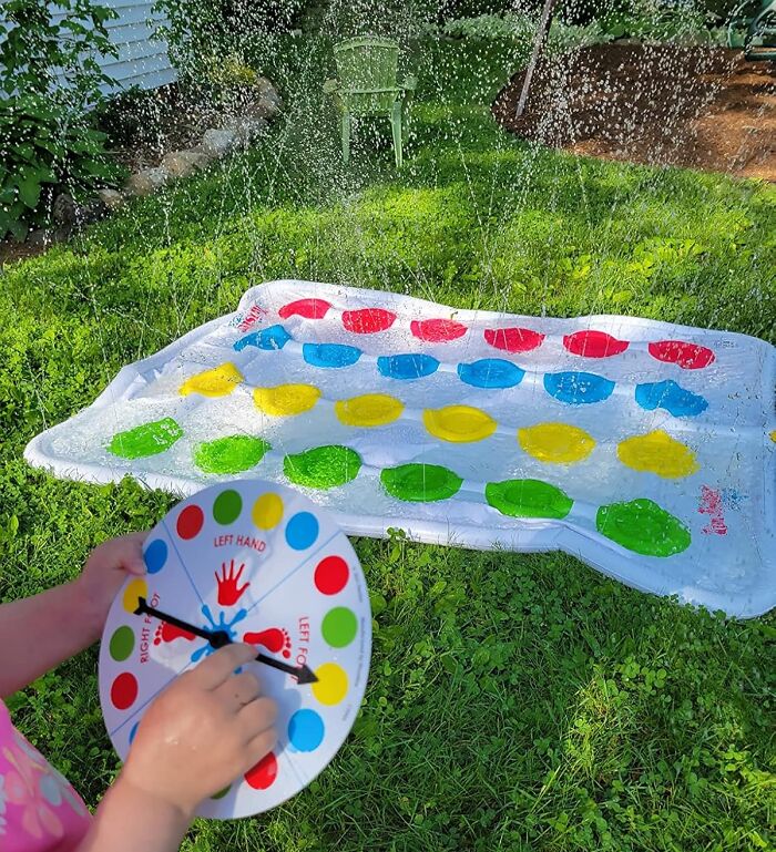 Child holding colorful spinner near a wet Twister mat on grass, illustrating bizarre finds affecting your bank account.