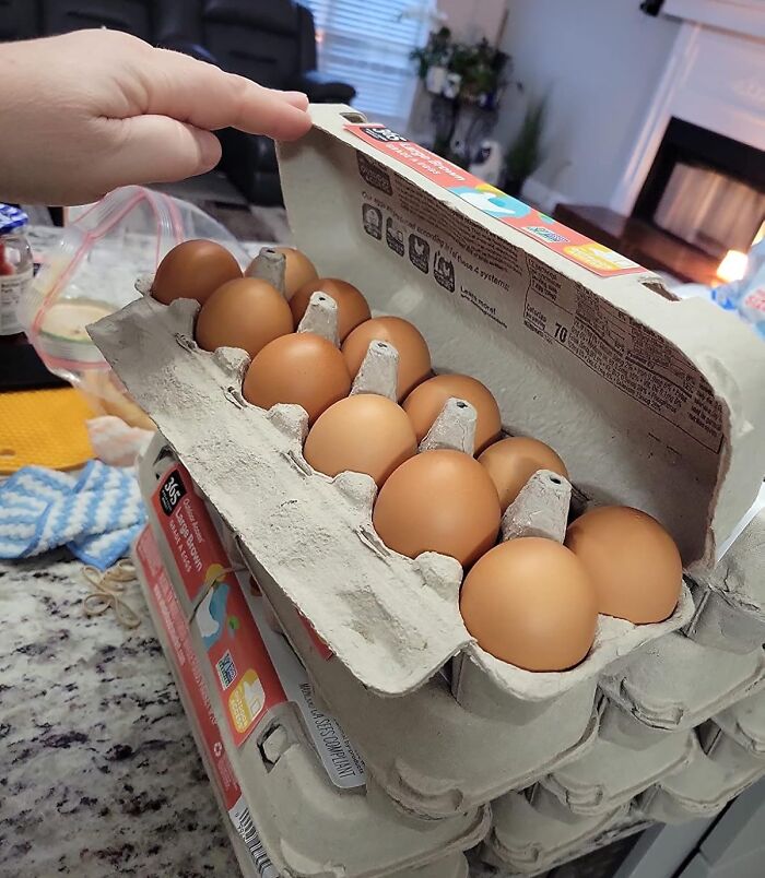 Carton of brown eggs stacked on a kitchen counter highlighting affordable Amazon Fresh staples compared to big box stores.