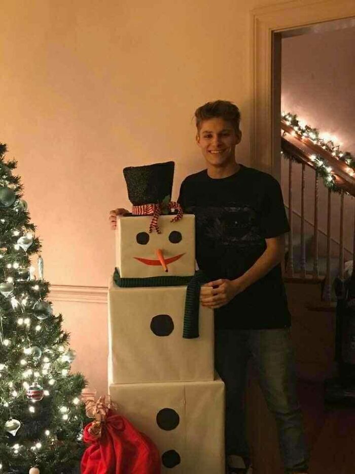 Young man standing next to a Christmas tree and a large snowman decoration, symbolizing a story about a late son&rsquo;s heartbeat.