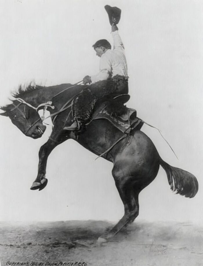 Vintage cowboy riding a bucking horse in a classic wild west scene showcasing authentic cowboy photographs.