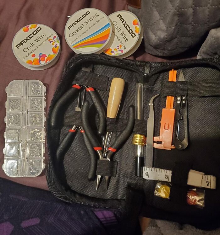 Jewelry crafting kit with pliers, craft wire, crystal string, and assorted small tools organized in a black case.