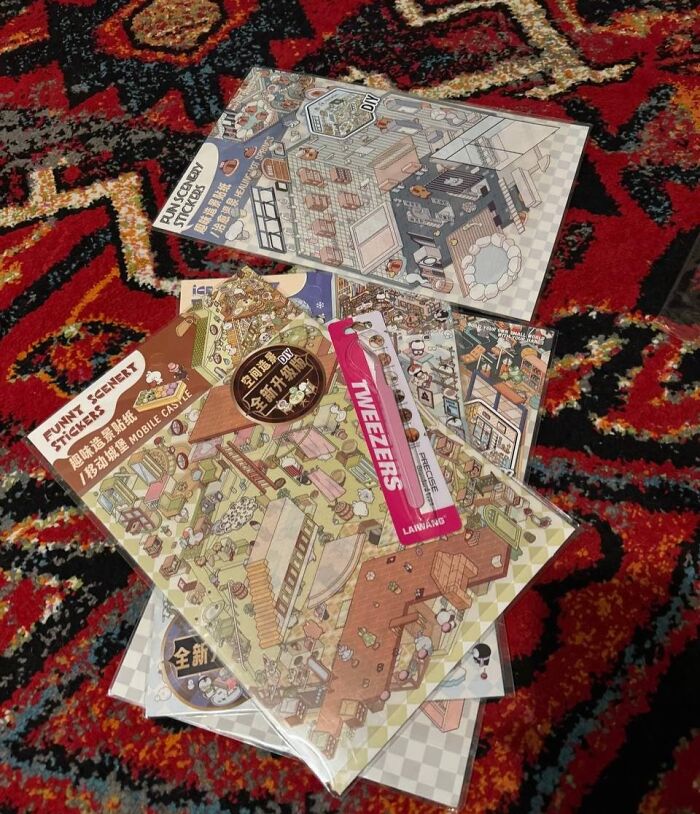  DIY crafting kits with detailed stickers and tools displayed on a patterned red and black carpet surface.