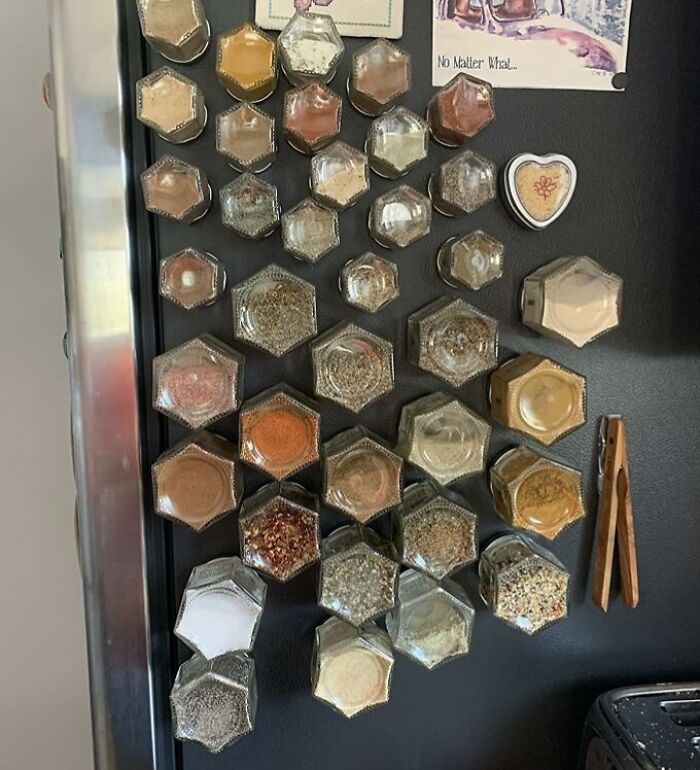 Hexagonal glass spice jars arranged on a magnetic board, showcasing best-selling kitchen items for easy access and organization.