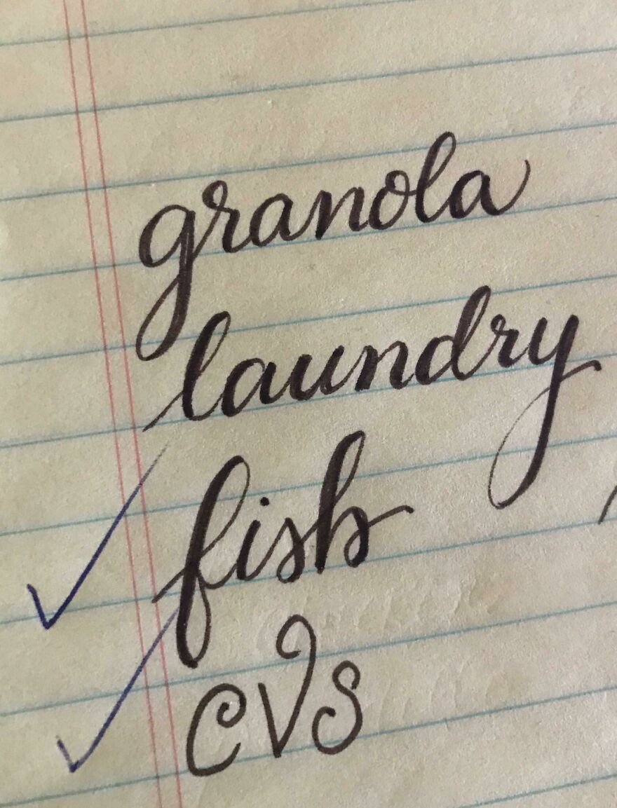Close-up of perfect handwriting examples on lined paper showing neatly written words granola, laundry, fish, and cvs