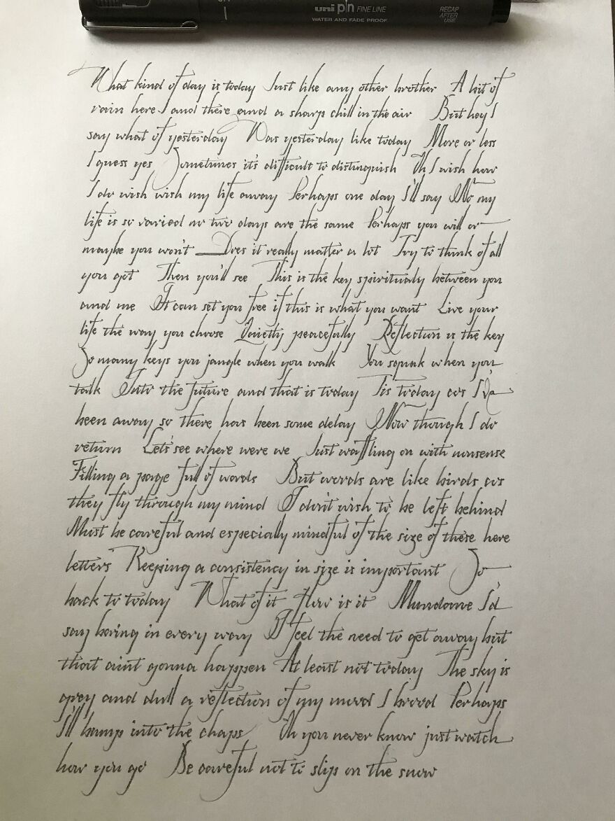 Elegant perfect handwriting example done with black ink pen on white paper, showcasing detailed calligraphy skills.