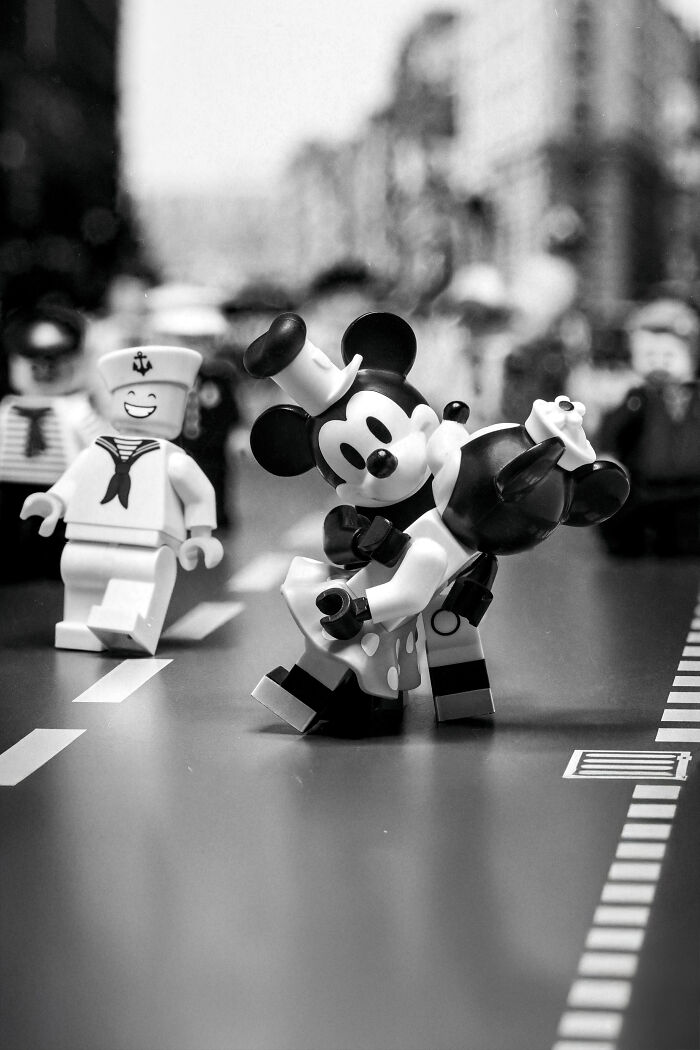 LEGO minifigures staged in a Hollywood-level scene with characters dancing on a city street in black and white.