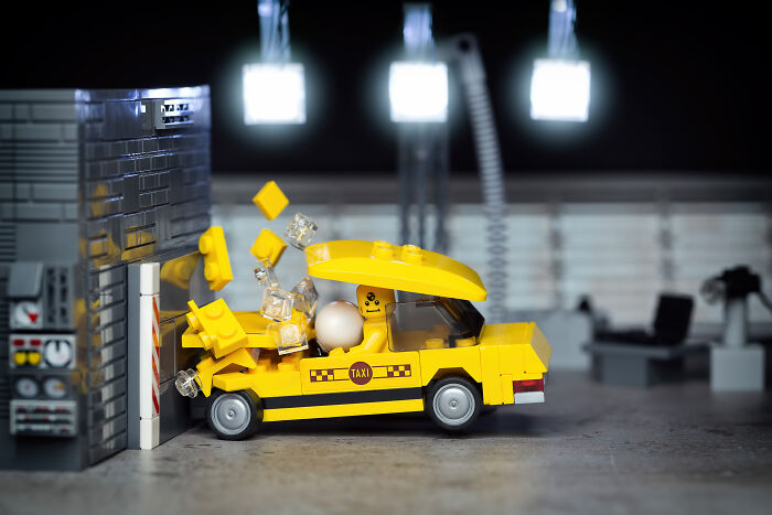 LEGO taxi crashing into a building, captured in a detailed Hollywood-level scene by a photographer.