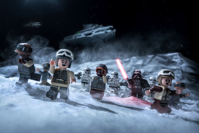 LEGO figures staged in a detailed Hollywood-level scene with soldiers and a villain holding a glowing red lightsaber.