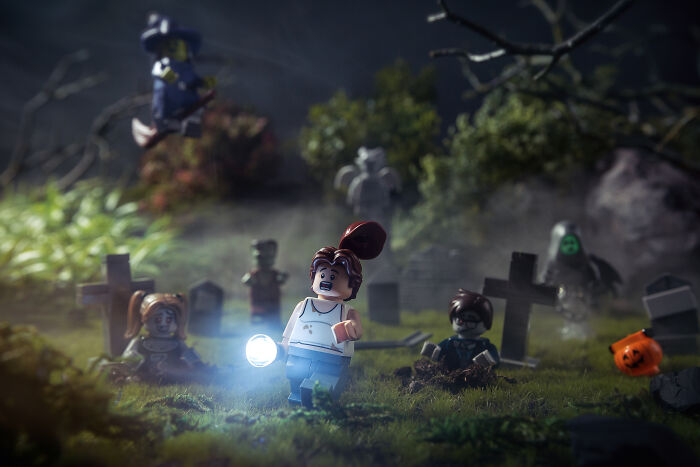 LEGO figures in a spooky graveyard scene with glowing flashlight, showcasing Hollywood-level LEGO photography skills.